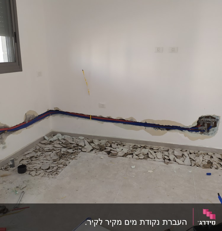 קירות פתוחים עם צינורות צבעוניים וכלי עבודה על הרצפה